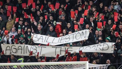Celtic fans hold up red cards as part of their protest against the board