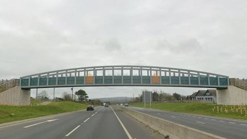 A road view of the Chiverton Cross bridge spanning the dualled A30 in Cornwall. It features a slightly domed over-rail, plus metalwork in yellow and turquoise paint.