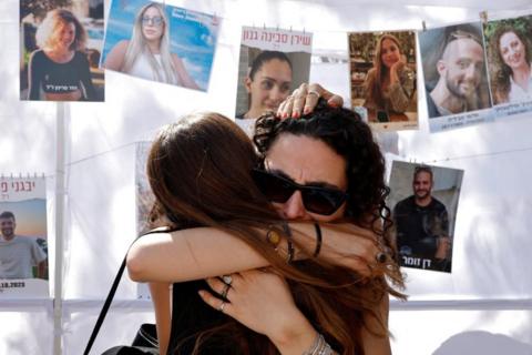 Two women hug in grief at the site of the Nova festival attack, on 7 October 2025