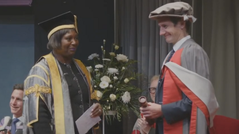 Alistair Brownlee - dressed in a red and grey graduation gown picking up his honorary degree at a ceremony at the University of York.