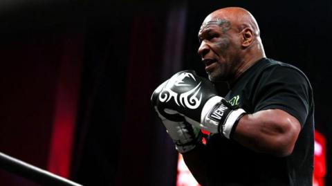 Mike Tyson with boxing gloves on doing an open workout for fans