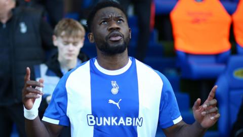 Oldham striker Mike Fondop looks to the sky with both hands raised