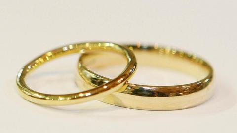 Close up generic image of two gold wedding bands, one resting slightly on top of the other
