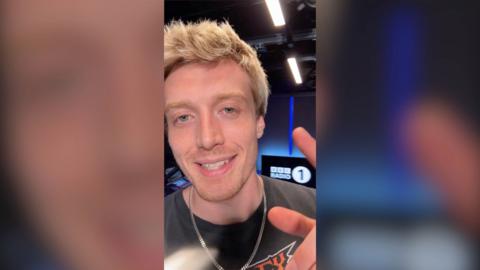 Radio 1 DJ Jack Saunders in the studio, smiling to the camera
