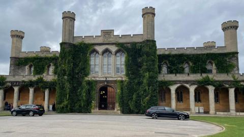 Grey-coloured path leading to the historic ivy-clad turreted court building in the grounds of Lincoln Castle