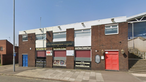 Image of a pub called the Nottingham Legend, which has a red door