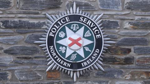 Police Service of Northern Ireland crest on brick wall
