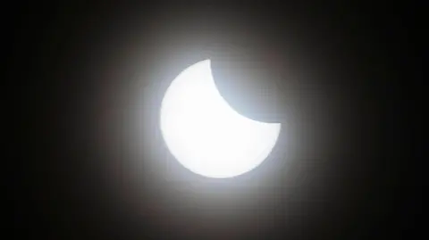 The sun is partially covered by the moon during a solar eclipse.