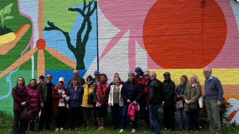 People in front of mural