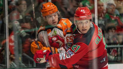 Jimmy Oligny (right) and Robert Dowd (left) fight for the puck