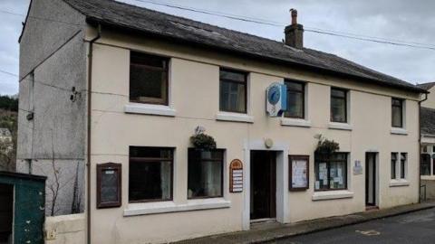 The exterior of the Garff Commissioners office, it is a rundown cream building.
