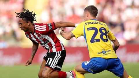 Romelle Donovan (left) challenges for the ball with Jay Stansfield