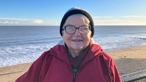 Paddy Thompson, wearing a hat and coat can often be seen in a swimming costume on this beach near Hornsea Floral Hall but she says a recent E. coli infection has made her wary of entering the water.