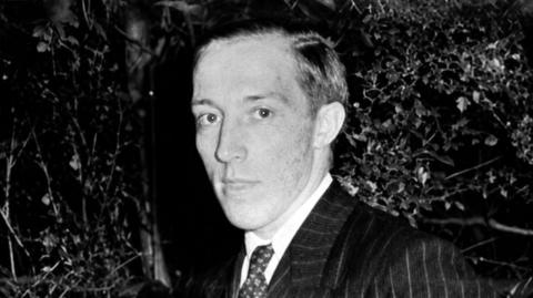 Vintage photograph of Herbert Leonard Mills, wearing a suit, posing for the camera