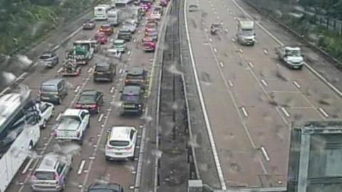 Traffic builds up on one side of a duel carriageway. On the other side, vehicles drive freely