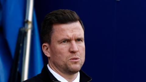 Wigan Athletic boss Gary Caldwell looks on towards the pitch from the dugout before his side's match against Exeter City.