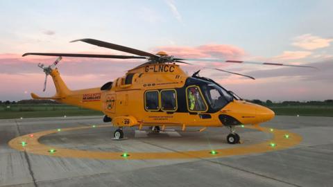 A Lincs and Notts Air Ambulance in on a helipad.