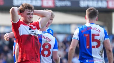 Middlesbrough's Tommy Conway, wearing red, holds his head following the draw at Blackburn Rovers