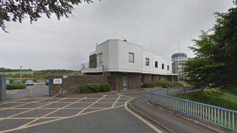 A picture of the Torridge District Council offices. It is a white building with a car park at the front.