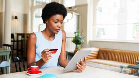 Woman with credit card and tablet shopping online