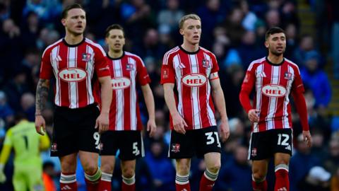 Exeter City's players look shell-shocked by their defeat at Manchester City earlier this month