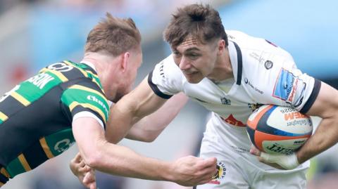 Campbell Ridl carries the ball while being tackled by a Northampton player