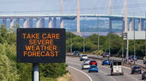 Heat warning matrix sign with the Severn Bridge in the background