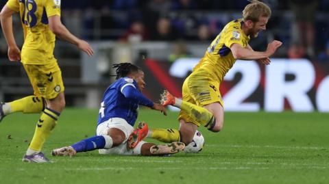 Cardiff's Gabriel Osho slides in on Ewan Henderson to earn a red card