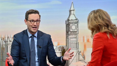 Chief Secretary to the Treasury Darren Jones appearing on Sunday with Laura Kuenssberg. He wears a navy suit, a pale blue shirt and a navy tie. 