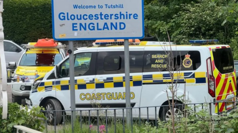 A coastguard van parked near a road sign