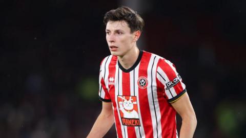 Anel Ahmedhodzic wearing a red and white Sheffield United shirt