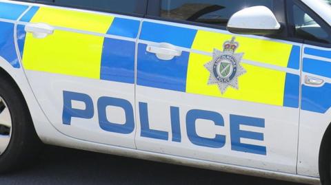 A close up of a Lincolnshire Police car showing the force's badge and the word police in blue capital letters. 