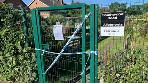 The gate to Southwood Road allotments with police tape stretched across it