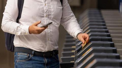 Anonymous shot of a man using a credit card to pass through ticket barriers