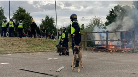 Police, police dog, crowd at the Holiday Inn in Manvers, Rotherham on 4 August