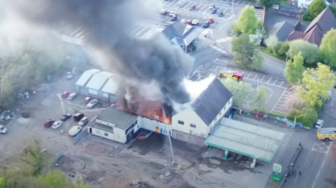 A drone shot of a fire affecting a building
