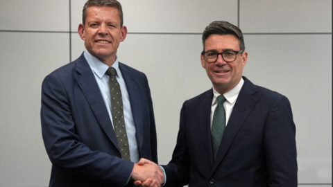 A formal picture of Rhun ap Iorwerth and Andy Burnham shaking hands