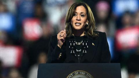 Kamala Harris gestures as she speaks at event