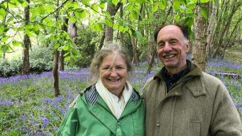 Sarah and David Best standing in a bluebell wood