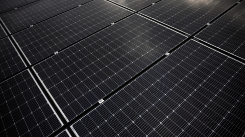 A view shows photovoltaic solar panels displayed on the roof of a building.