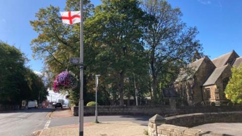 A St George's flag on display near the top of a lamppost on Leeds Road, Outwood, Wakefield.