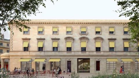 A concept image of the renovated building, as seen from the side. It is a large three story Georgian building showing yellow awnings on every window, and a public square with seating in the foreground.