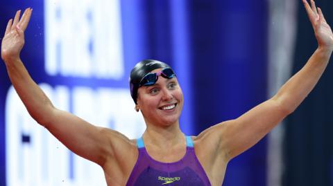 Freya Colbert with her arms held high after a race