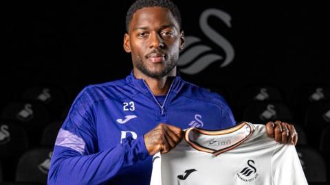 Ricardo Santos holding a Swansea City shirt