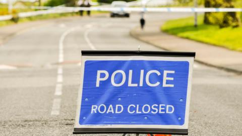 Police close a road during a security alert.
