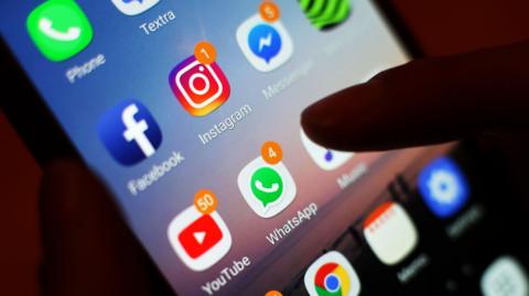 A close up of a smart phone screen with different apps on it including Instagram, Facebook and WhatsApp.