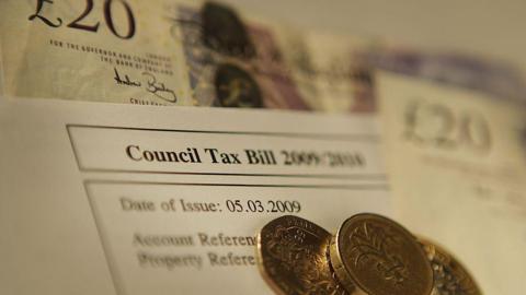 A stock photo of a council tax bill along with some £20 notes and pound coins.