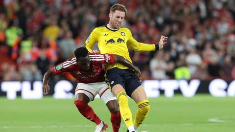 Joe Rodon of Leeds United is challenged by Arnaud Kalimuendo of Nottingham Forest.