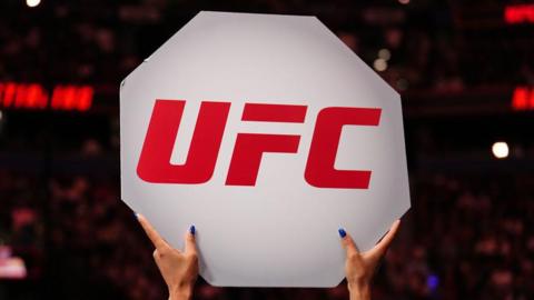 A UFC sign is held up at an event