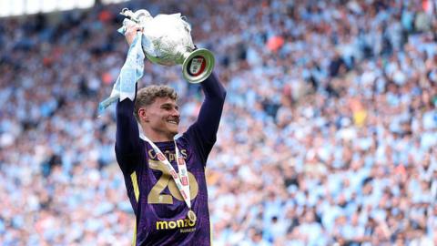 Carl Rushworth holds the 2025-26 Championship trophy aloft
